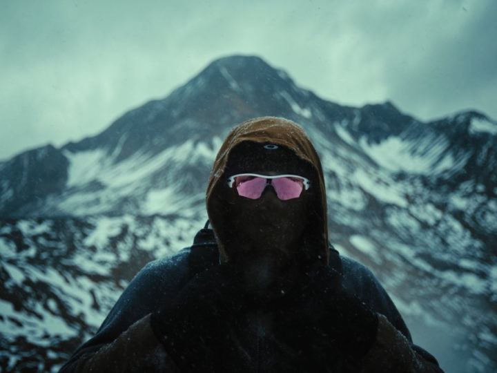 Person wearing Oakley sunglasses on a misty mountain summit